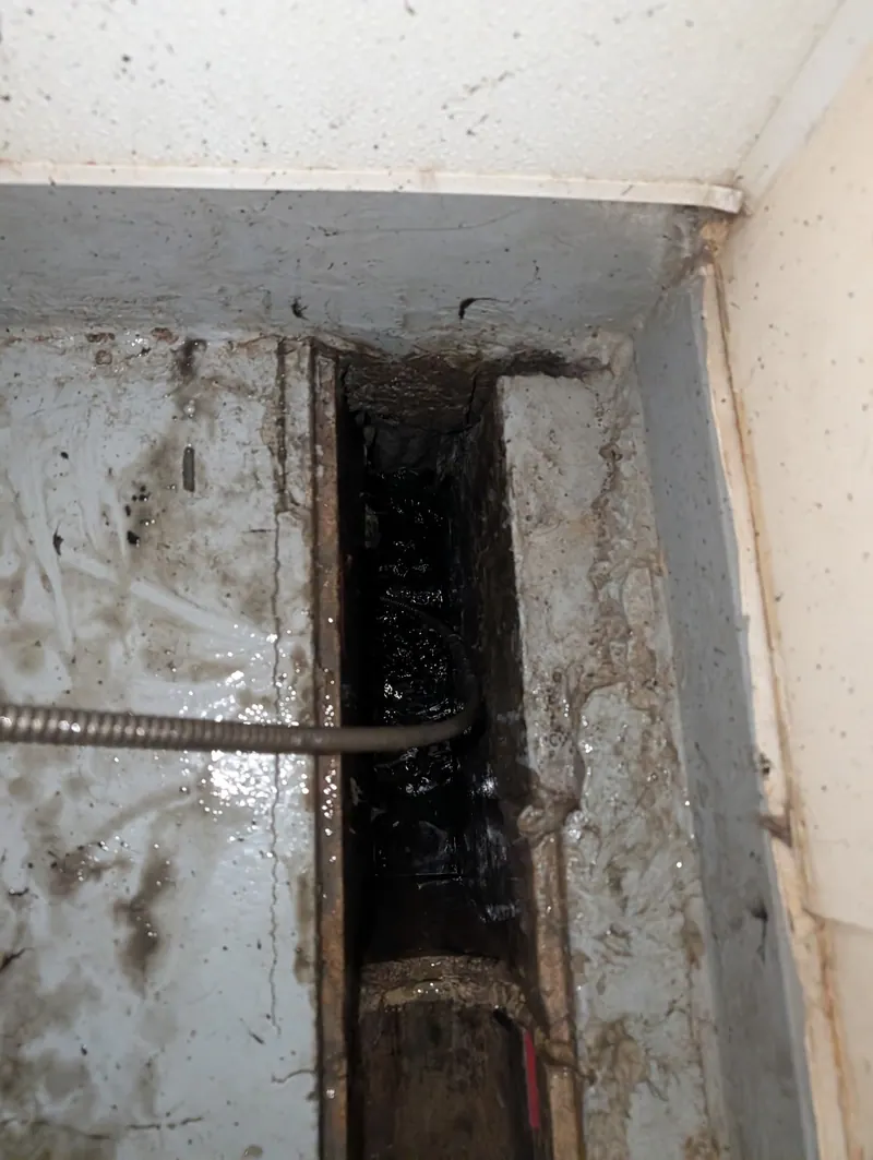 Drain cable clearing debris from a commercial trench drain