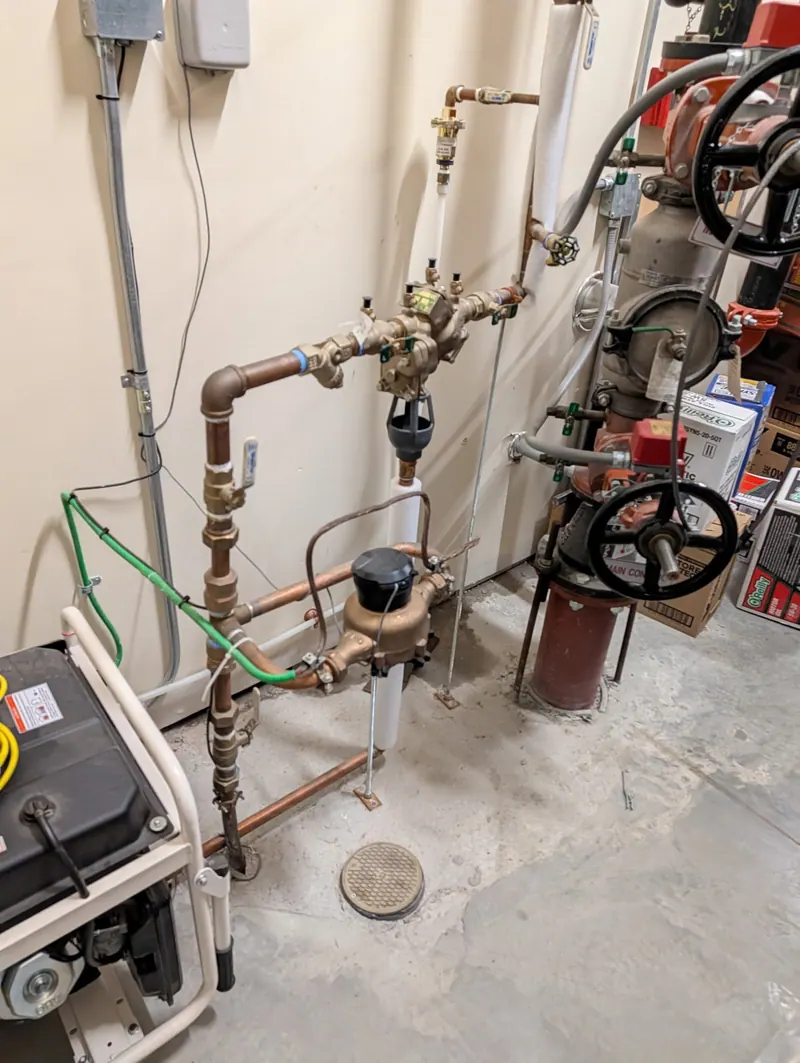 Commercial water service room with valves, meters and copper piping serviced by Fullerton plumbers