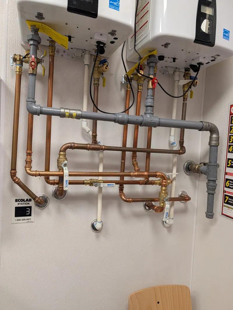 Two wall mounted tankless water heaters installed by Fullerton with new copper water piping