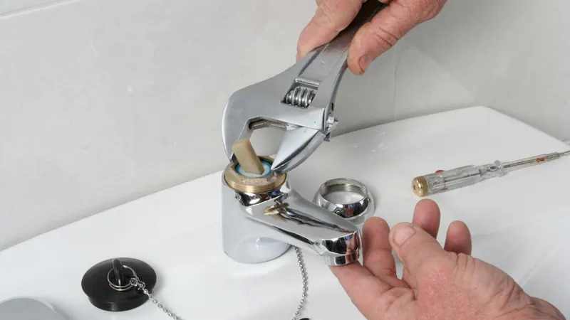 Plumber installing a new bathroom faucet