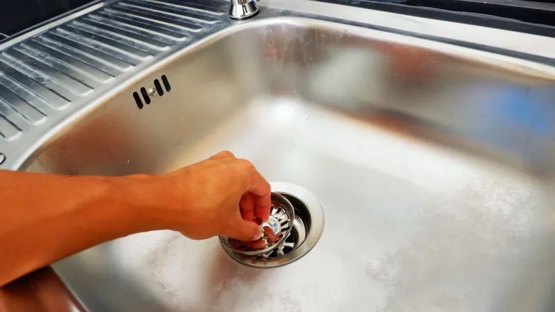 Technician working a grease clogged kitchen drain before hydro jetting