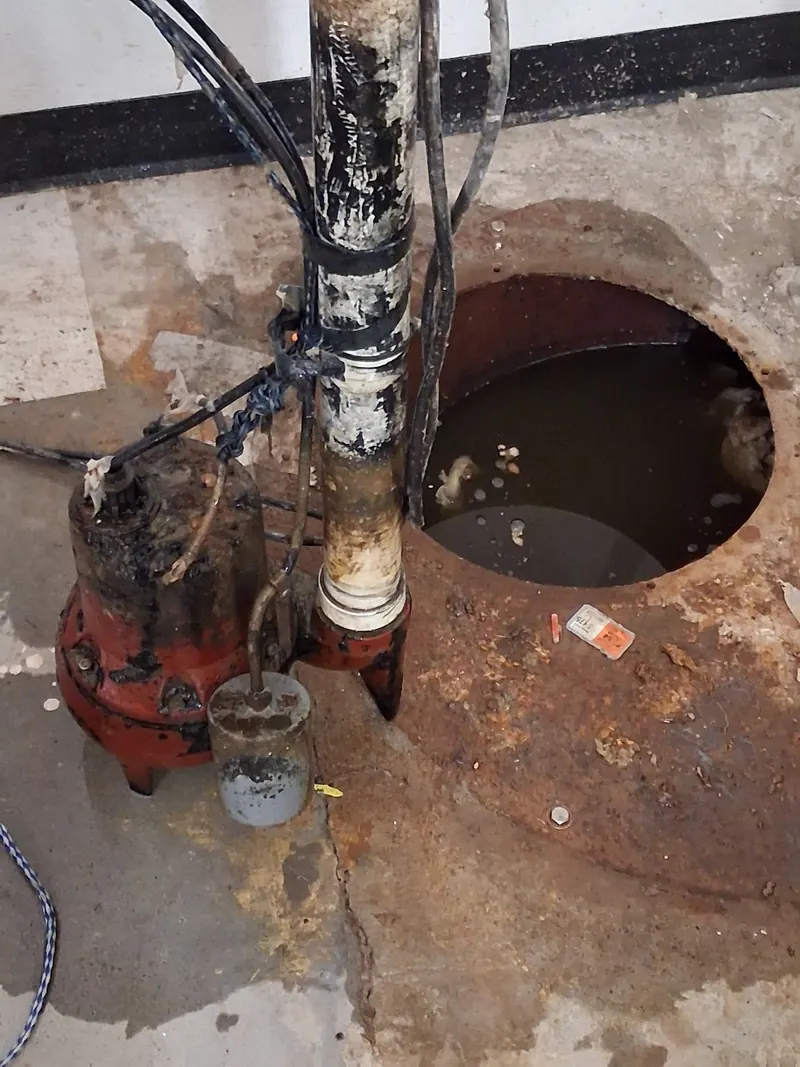 Sewage ejector pit and pump being serviced by Fullerton in a basement